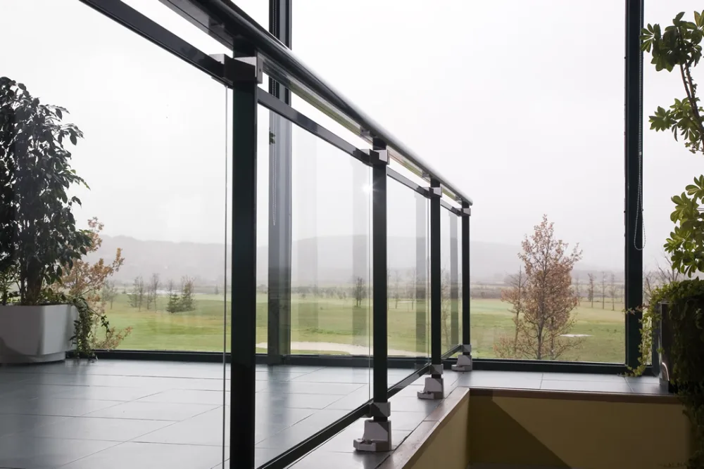 Barandilla de vidrio con perfil de aluminio en una terraza acristalada